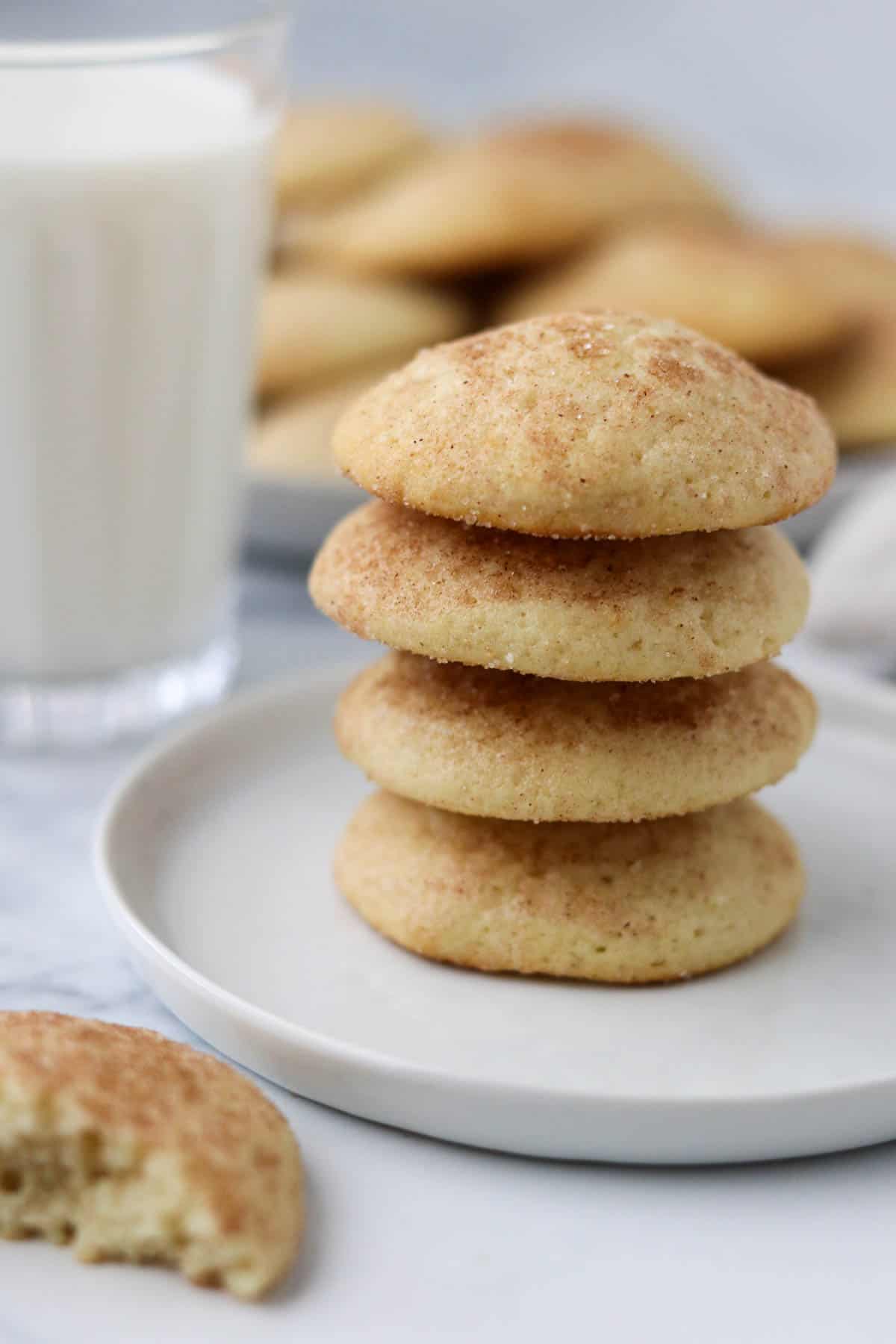 Stack of buttermilk cookies next to a glass of milk.