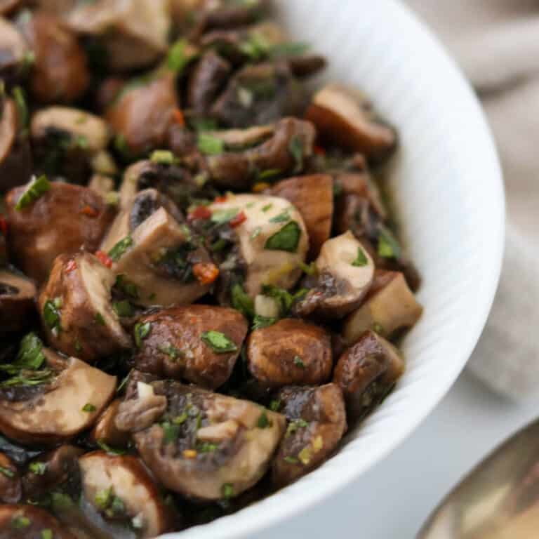 Close up of Easy Quick Pickled Mushrooms in a white bowl.