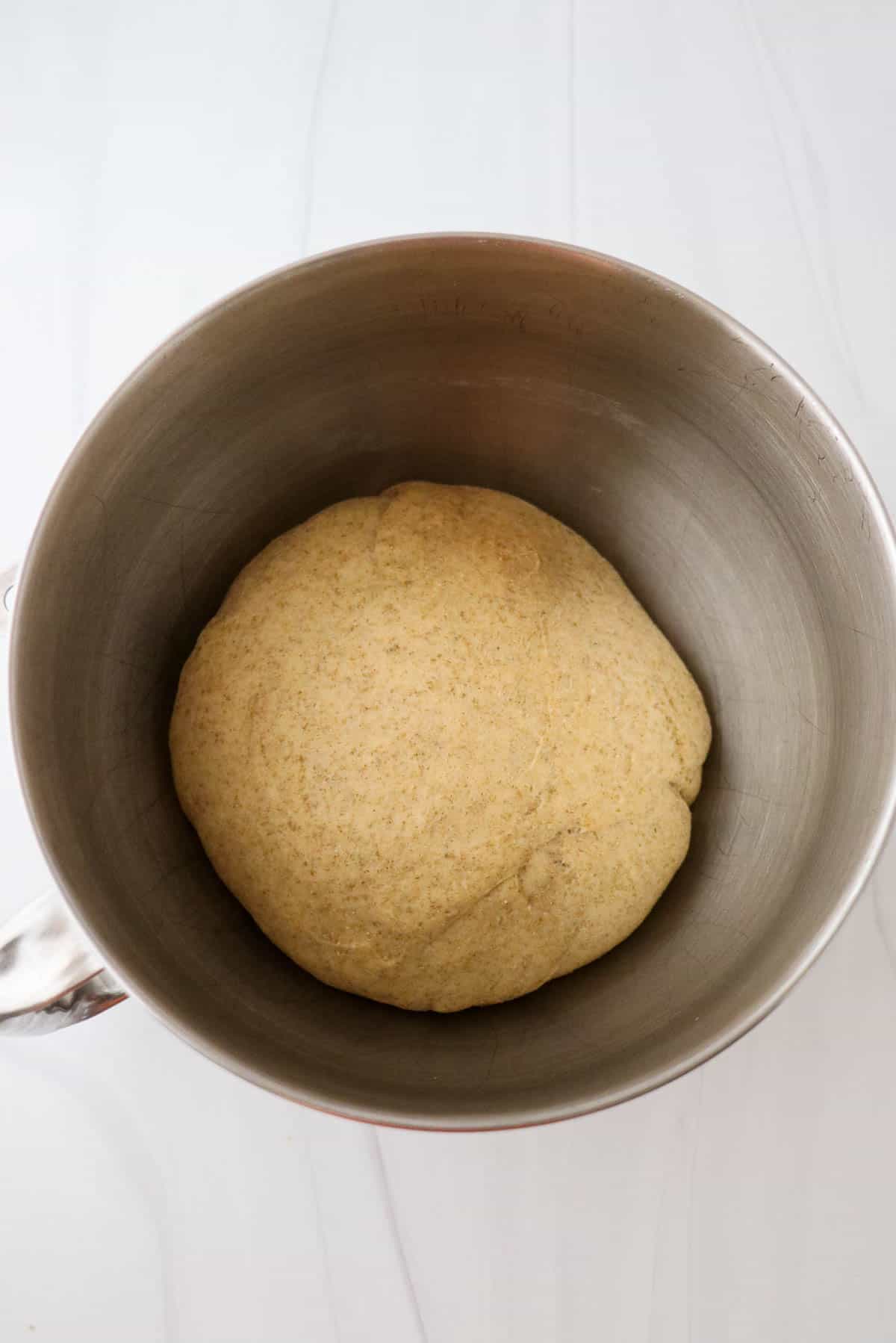 Risen rye dinner roll dough in a mixing bowl.