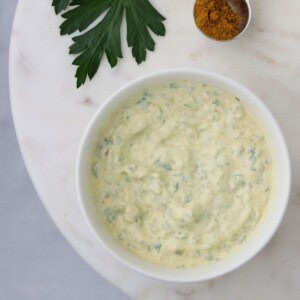 Close up of a bowl of remoulade on a marble plate.