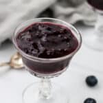 Swedish Blueberry Soup (Blåbärsoppa) in a glass dish next to a spoon.