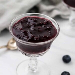 Swedish Blueberry Soup (Blåbärsoppa) in a glass dish next to a spoon.