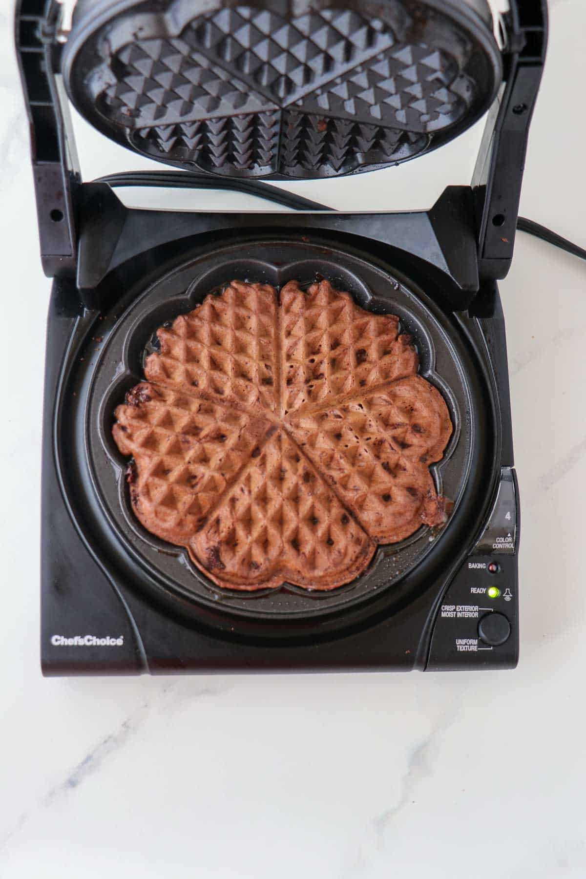 Chocolate waffle in a heart-shaped waffle maker.