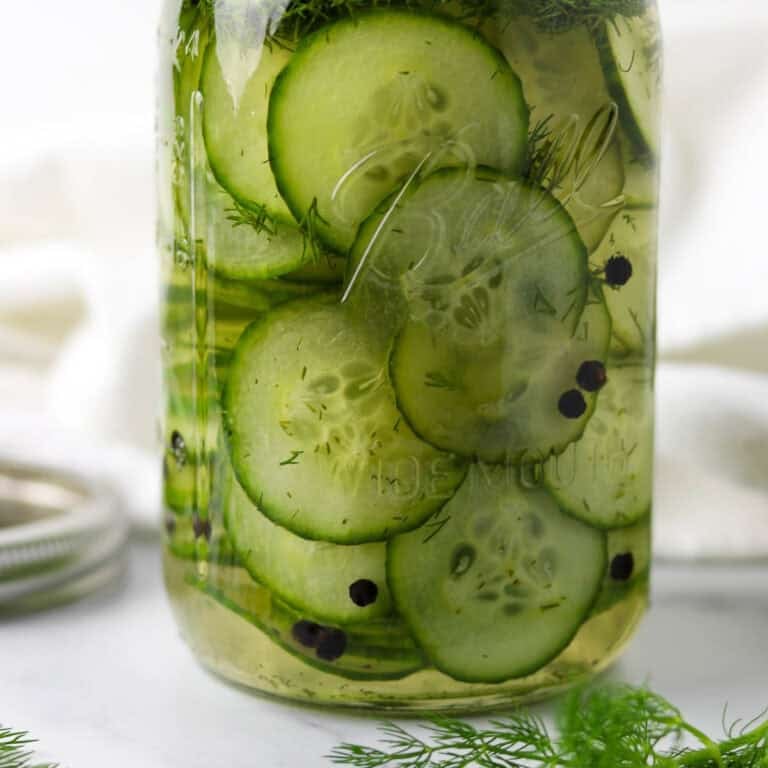 Jar of Quick Swedish Pickled Cucumbers next to fresh dill.