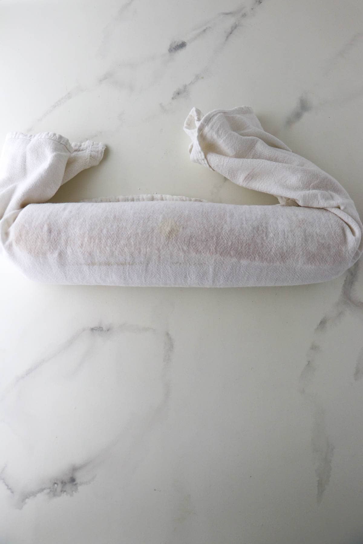 Rolled up rulltårta in a kitchen towel.
