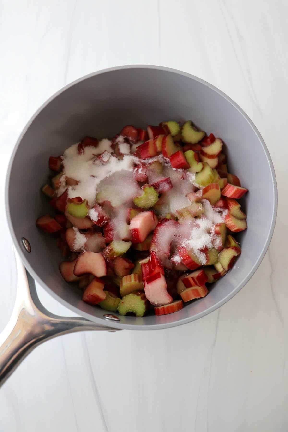 Cut rhubarb and sugar in a saucepan.