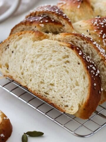 Cardamom Bread sliced on a cooling rack.