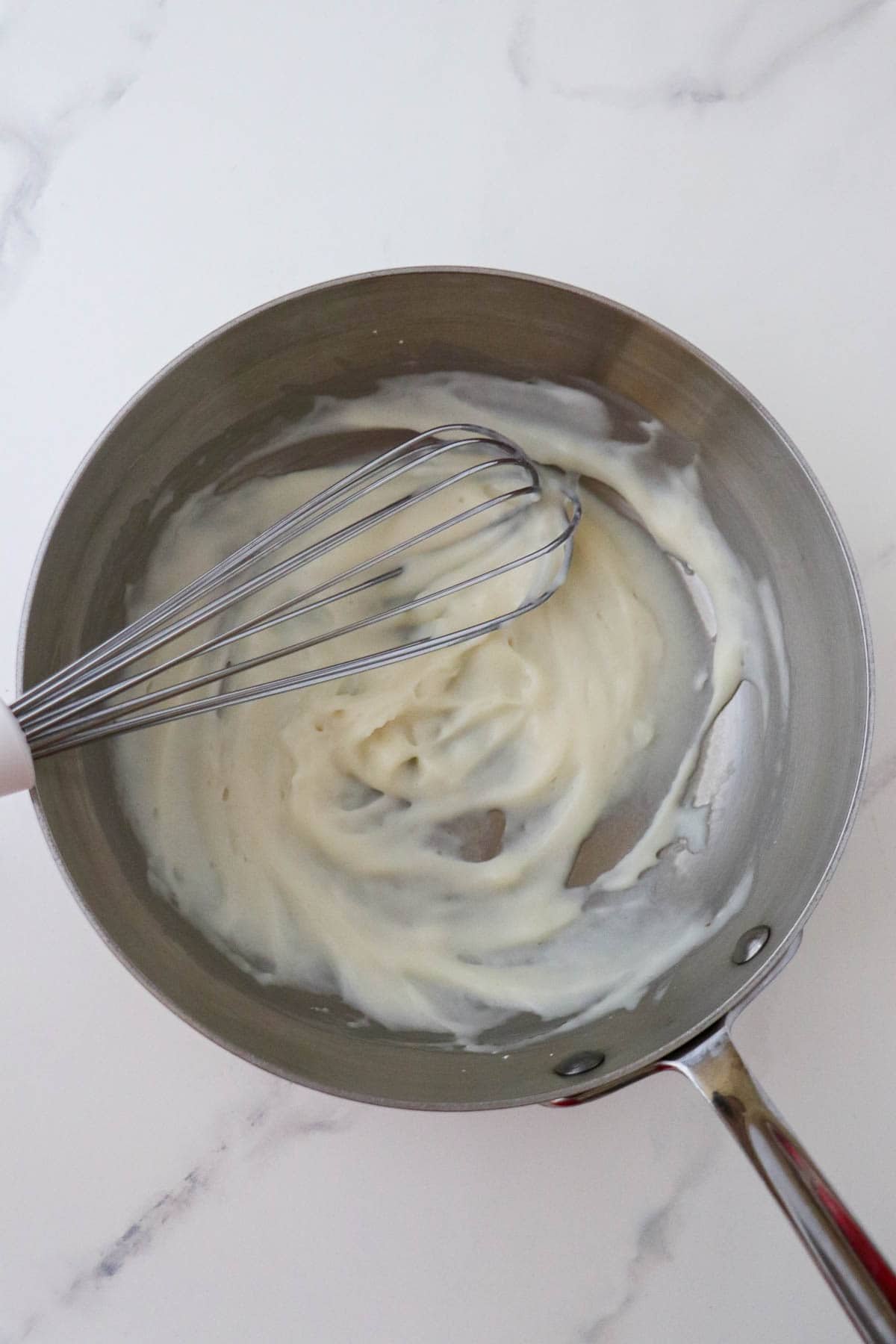 Tangzhong in a metal saucepan with a whisk.