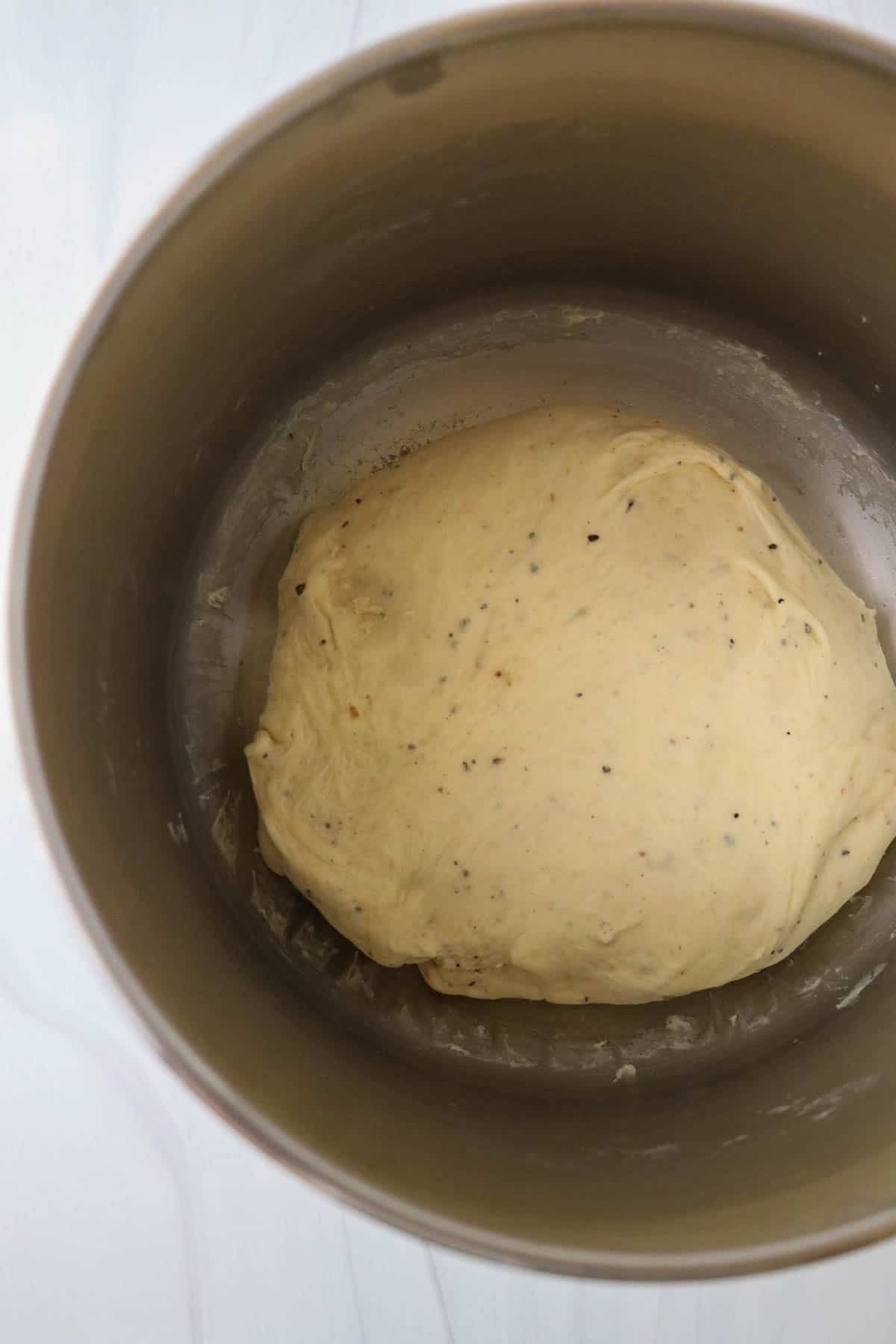 Cardamom bread dough in a metal bowl.