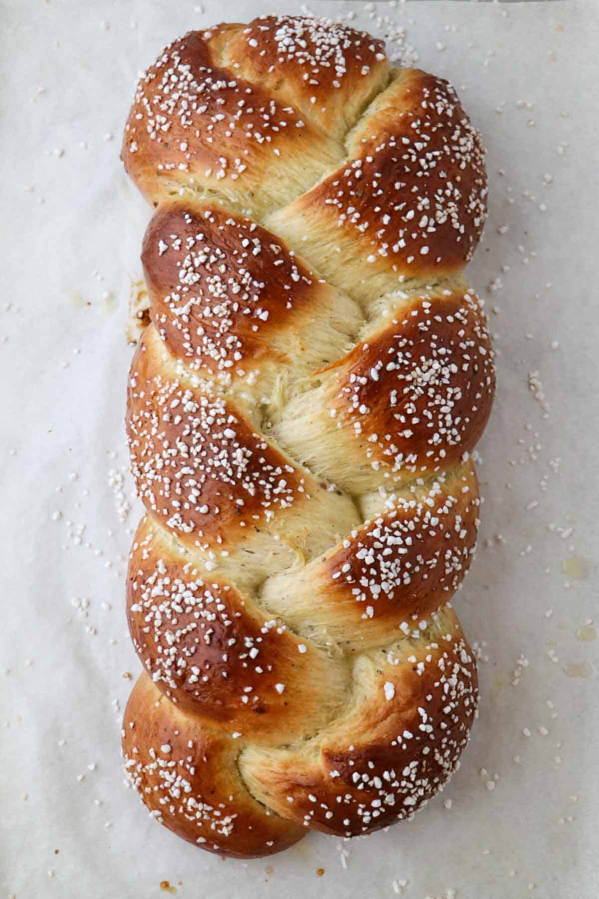 Baked loaf of Cardamom Bread (Finnish Pulla) on parchment paper.
