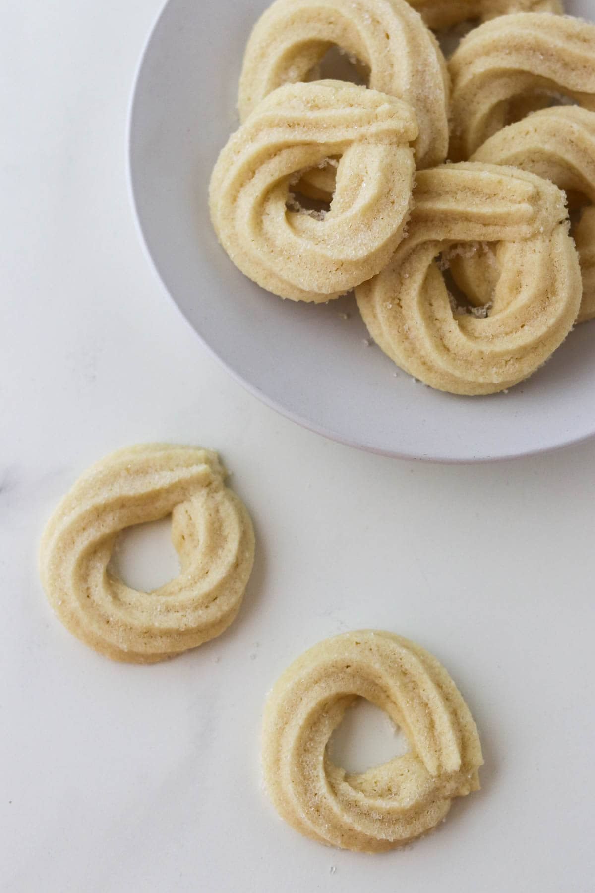 Danish Butter Cookies (Valiljekranse) on a plate with two off to the side.