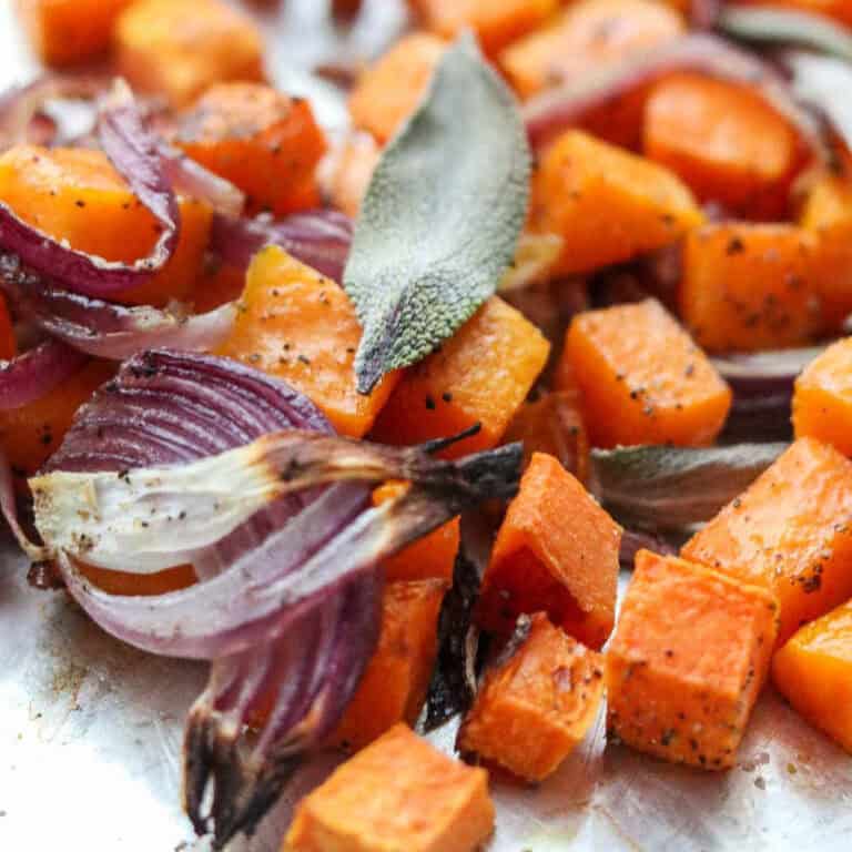 Roasted squash cubes and red onion slices topped with a sage leaf.