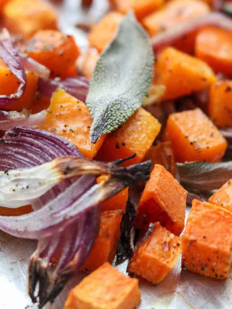 Roasted squash cubes and red onion slices topped with a sage leaf.