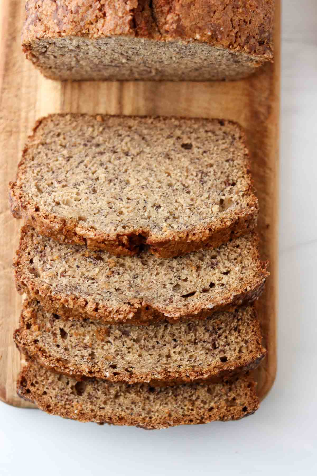 Cardamom Banana Bread sliced on a wooden cutting board.
