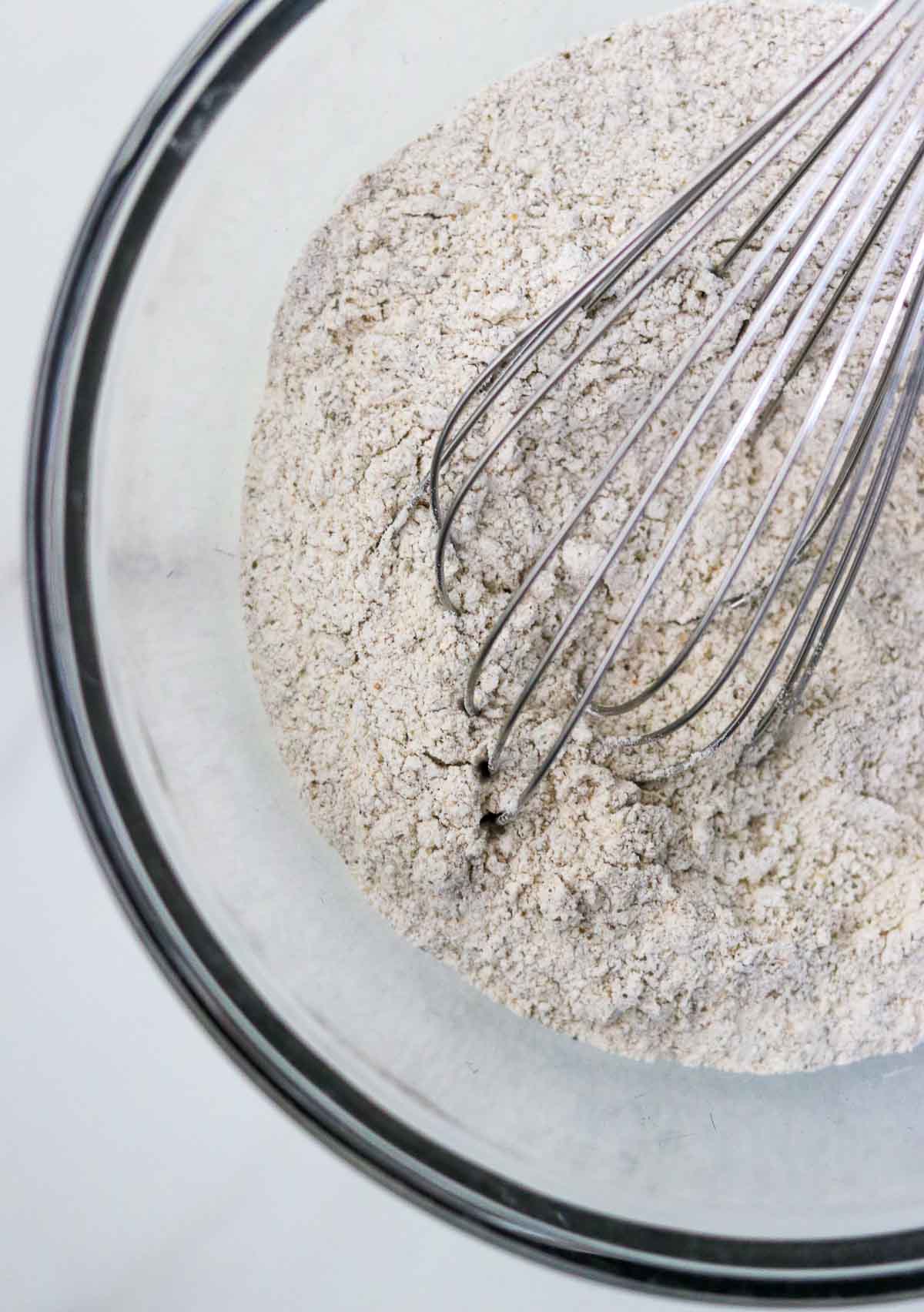 Dry ingredients in a bowl with a whisk.