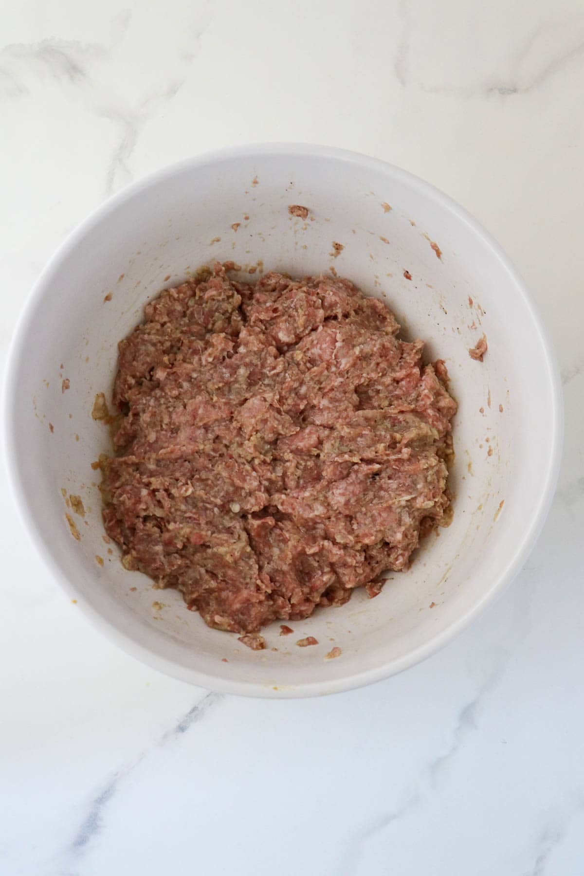Meatloaf mixture in a white bowl.