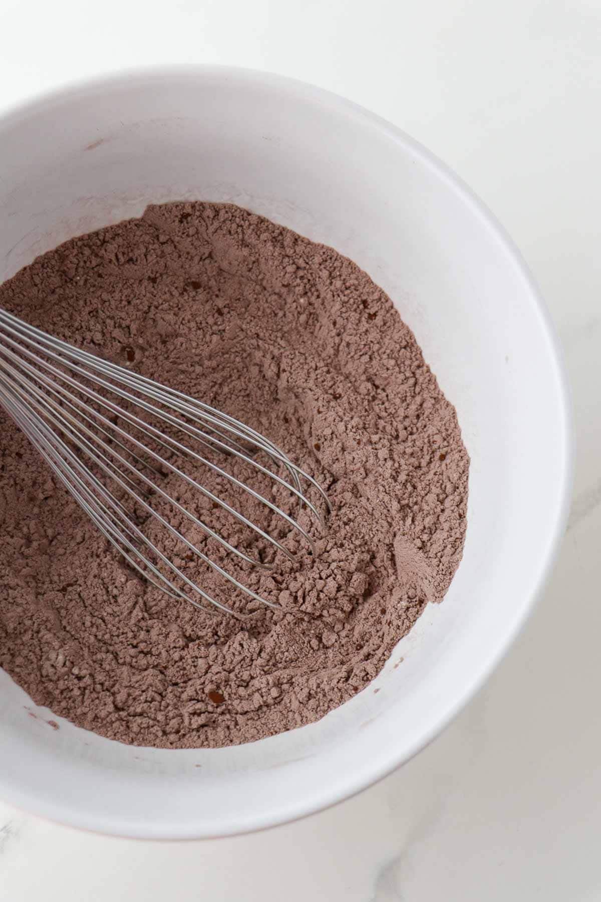 Dry ingredients for Swedish Love Cake (Kärleksmums) in a bowl with a whisk.