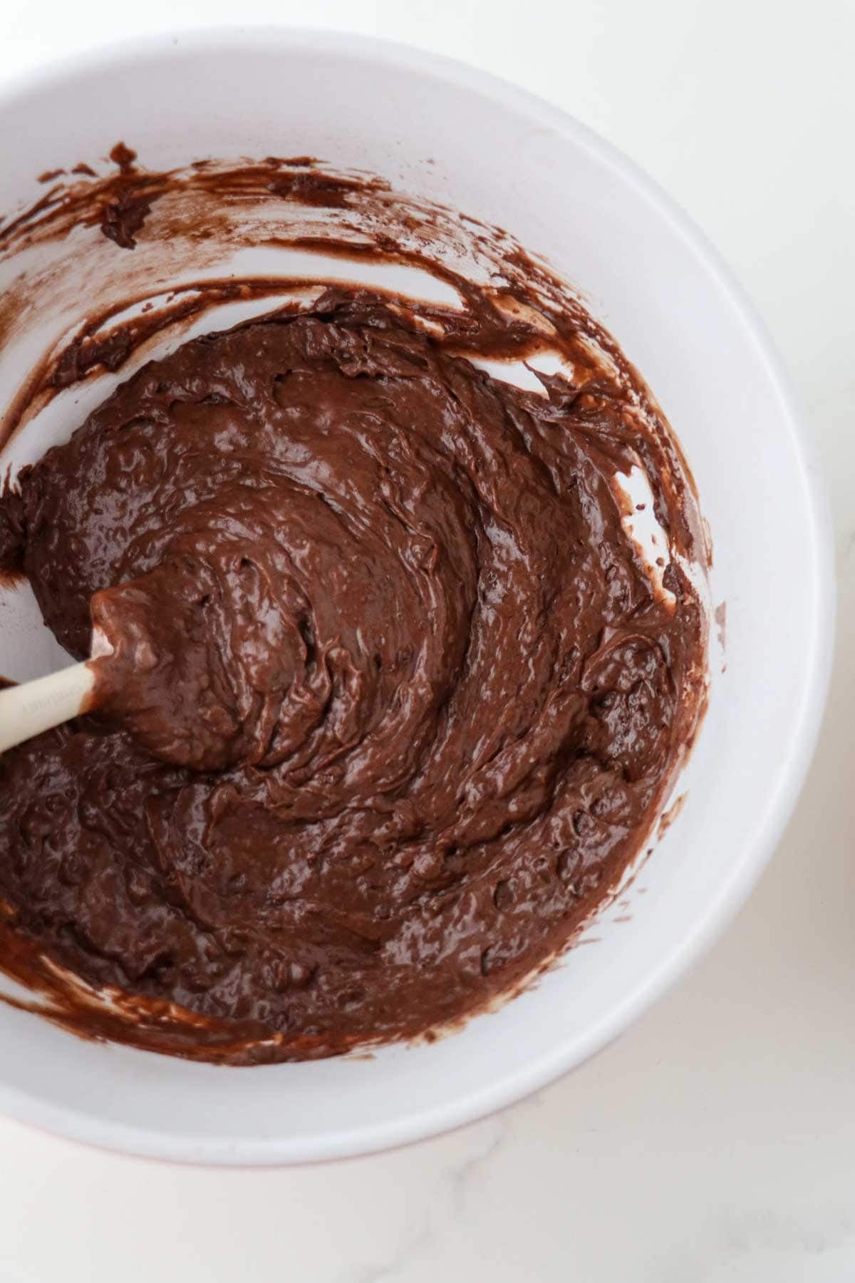 Batter for Swedish Love Cake (Kärleksmums) in a white bowl with a spatula.