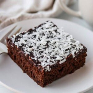 A slice of Swedish Love Cake (Kärleksmums) on a plate with a fork.
