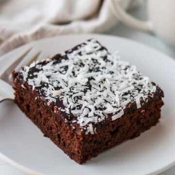 A slice of Swedish Love Cake (Kärleksmums) on a plate with a fork.