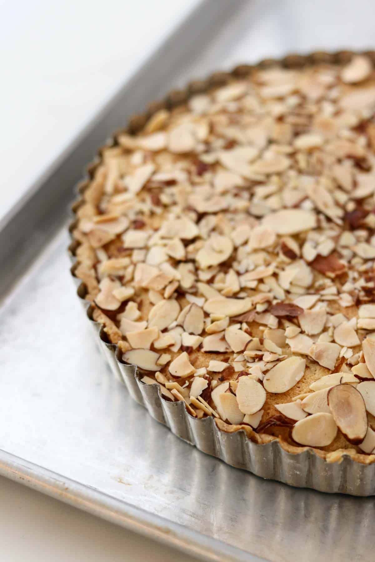 Baked Lingonberry Almond Tart in a 9 inch tart pan on a baking sheet.