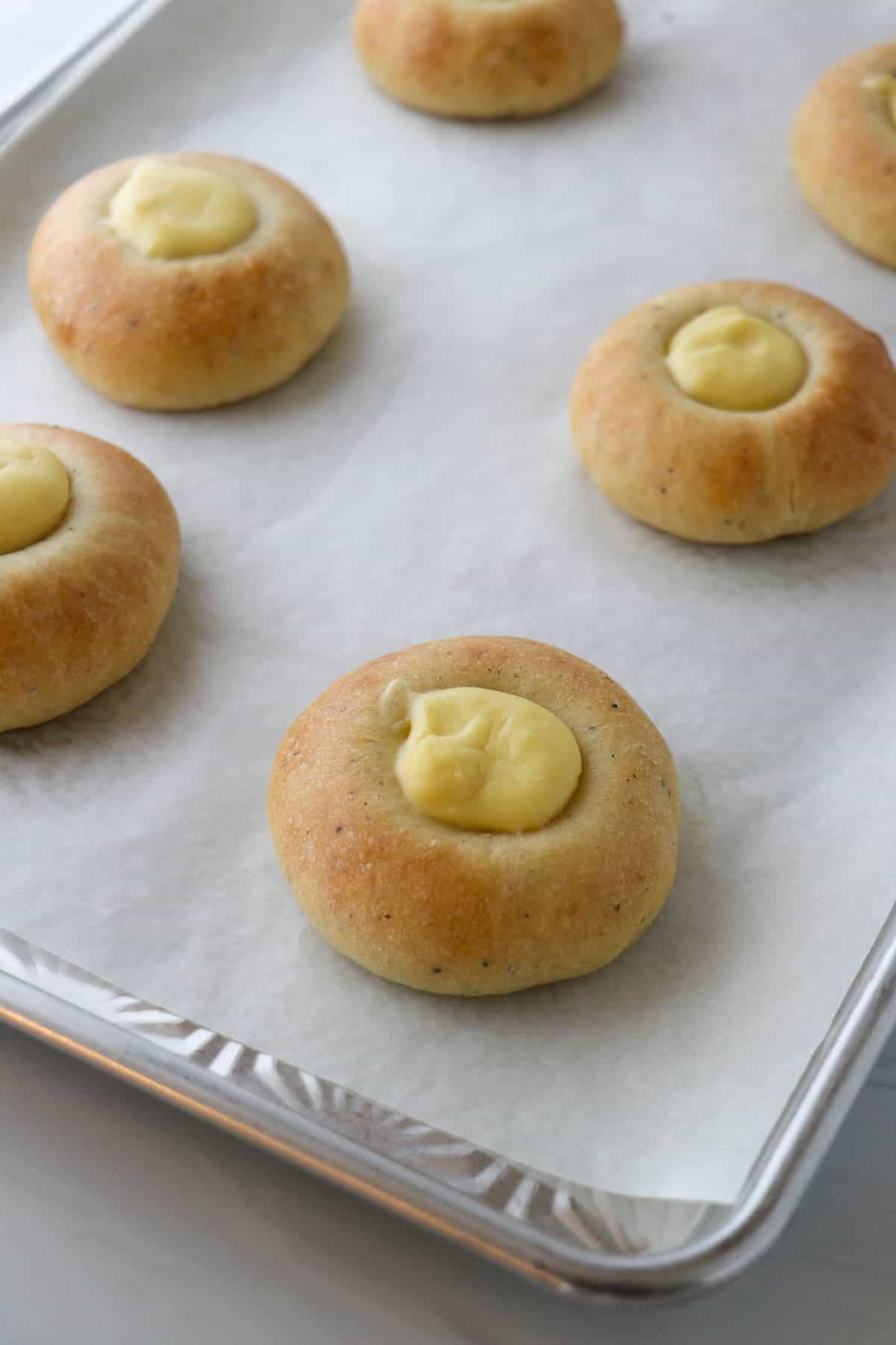 Freshly baked Norwegian Skoleboller on a baking sheet.