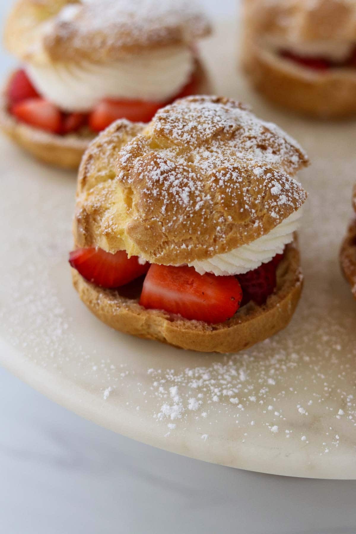 Danish cream puffs on a marble serving plate.