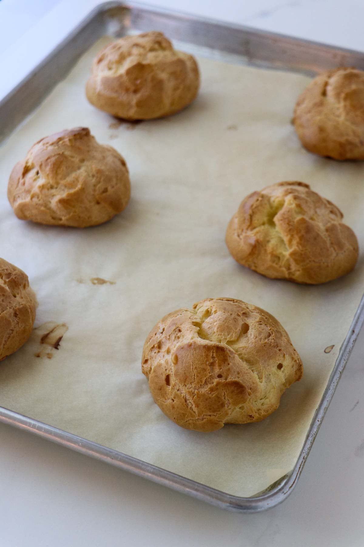 Baked Cream Puffs on a baking sheet.