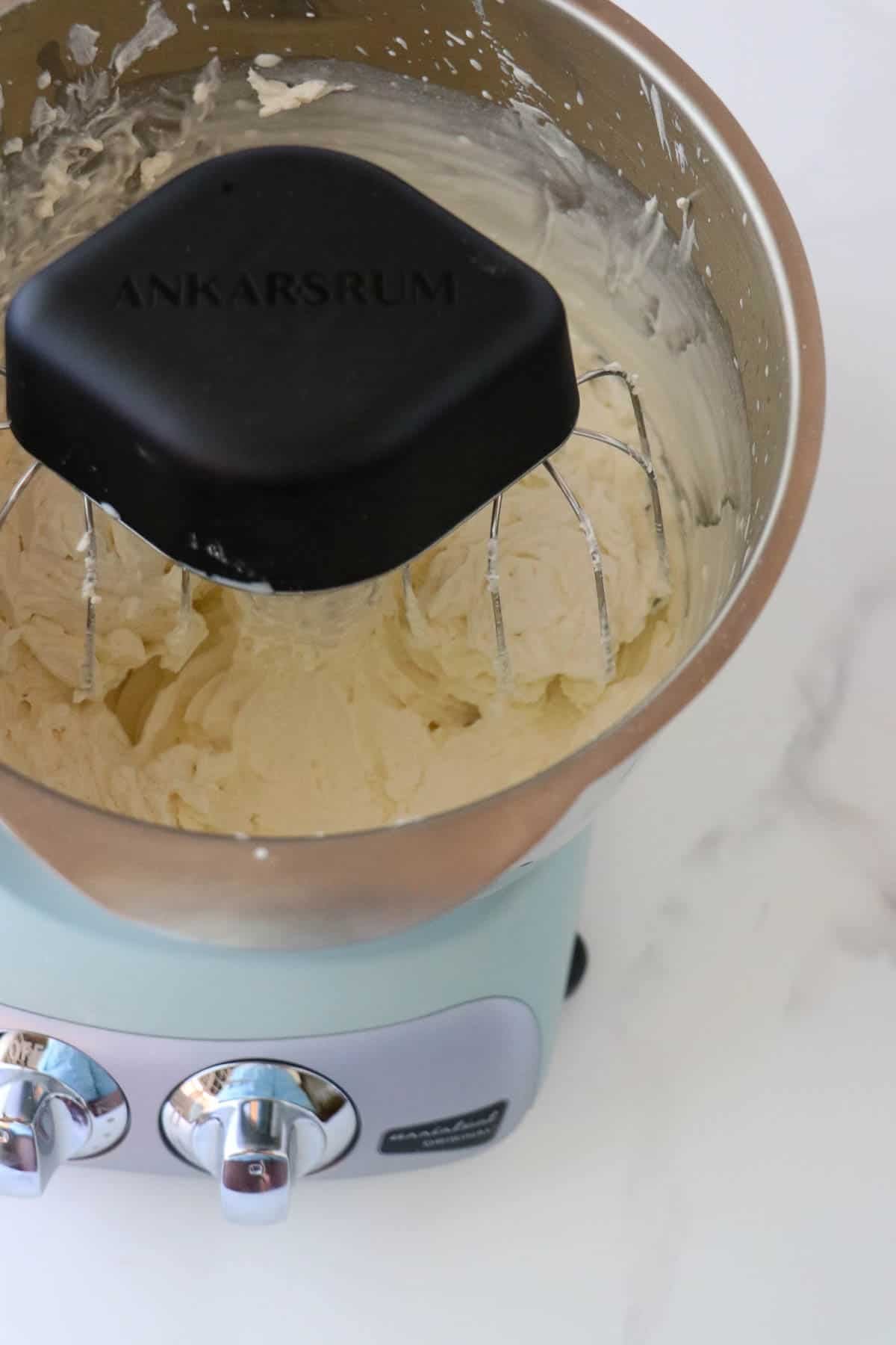 Whipped cream in a stand mixer bowl.