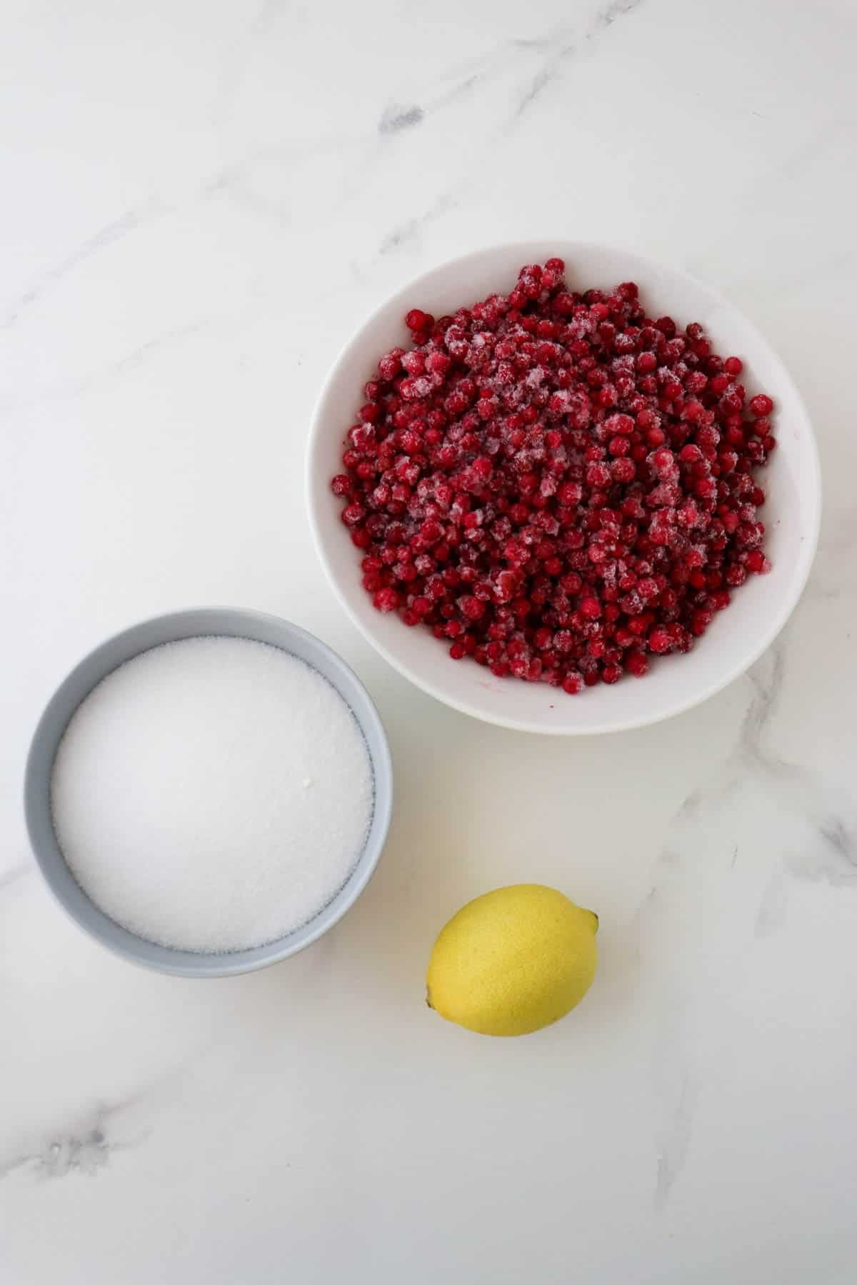 Ingredients needed to make Homemade Lingonberry Jam: frozen lingonberries, sugar and lemon.